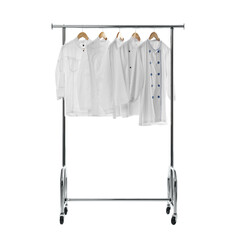 Different chef's coats on clothing rack against white background