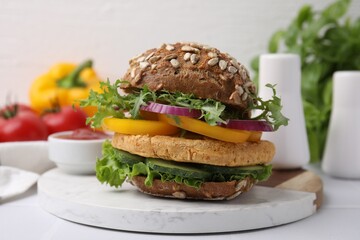 Delicious vegan burger with chickpea cutlet on white table, closeup