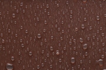 Water drops on brown background, top view