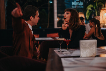 A young couple engages in a heated argument while dining at a stylish restaurant, conveying tension during a night out.