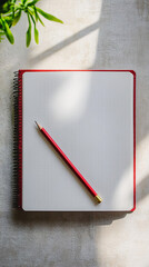 red notebook and pencil on a concrete tabletop