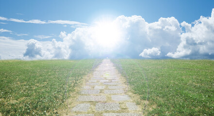 緑の野原を貫く遠く地平線へ続く石畳の一本道　背景の青空と雲...