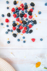 Background of fresh fruits and berries. Ripe blackberries, blueberries, raspberries. Mix berries and fruits. Top view on white wooden background. Background berries and fruits. Black-blue and red food