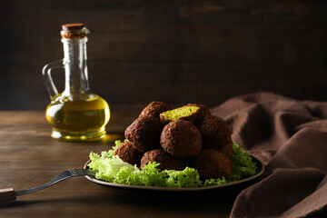 Ready falafel with ingredients on a brown background.