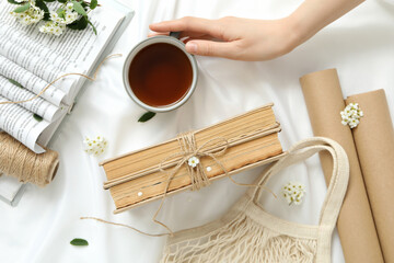 Books with a cup of tea, on a light background with flowers.