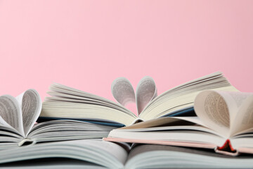 Books with wrapped pages on a pink background.