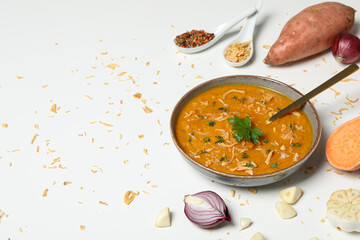 Sweet potato puree in bowl and ingredients on white background, space for text