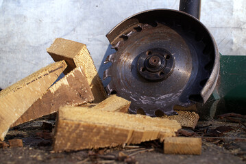 Circular saw blade slices through logs, scattering wood shavings and debris around a rustic workshop