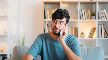 Mobile offer. Phone conversation. Curious pensive serious smart guy listening using gadget at light...