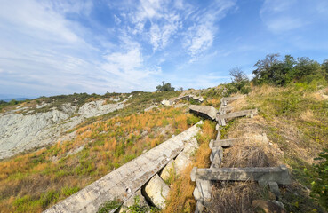 Hill landscape with storm clouds, forming tornado, dramatic weather scene, dark skies over rolling hills.