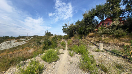 Hill landscape with storm clouds, forming tornado, dramatic weather scene, dark skies over rolling hills.