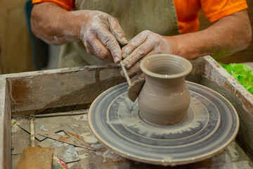 Close up of a potter's hands creating a ceramic vase on the craft wheel. © Sergio Palacio