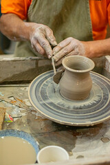 Close up of a potter's hands creating a ceramic vase on the craft wheel. © Sergio Palacio
