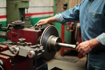 Mechanic turns on the grinding lathe