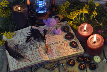 Mystic still life with book of spell, runes and witchy ritual objects on old altar table. Occult, esoteric, wicca, Halloween and gothic concept. No foreign language, all symbols are fictional