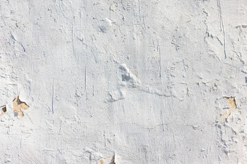 Old concrete wall with white peeling paint, background texture