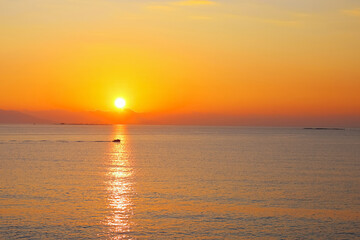 Fototapeta premium Sun setting over the calm sea