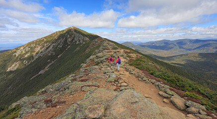 Hikers trekking along Franconia mountain ridge traverse at Mont Lafayette with a beautiful landscape background, New Hampshire, USA