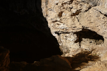 Sunlit cave entrance with rocky terrain
