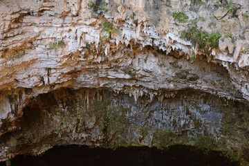 Cave with layered rocks and greenery