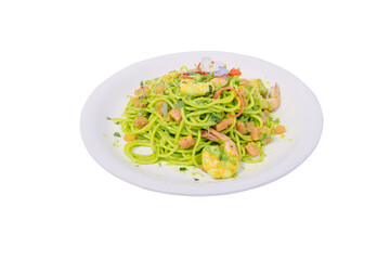 A plate of green spaghetti with shrimp, vegetables, and a creamy avocado sauce, garnished with a flower and chili peppers.