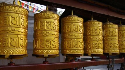 Golden Tibetan prayer wheels from the Buddhist temple Swayambhunath stupa a UNESCO world heritage site.