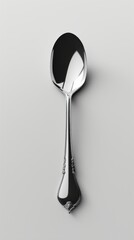 Elegant silver spoon resting on a minimalist surface, showcasing its polished finish and intricate design details