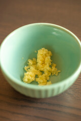  Minced Garlic Clove in a Small Blue Bowl Close-Up