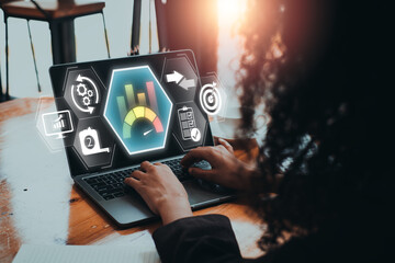 A business professional uses a laptop to analyze benchmarking data on a digital dashboard, aiming to enhance performance and efficiency.
