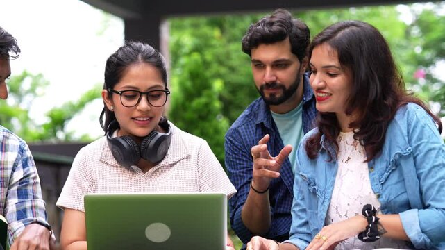 Indian girls and boys gather with laptops and study material,sharing ideas as they think critically about their assignments displaying teamwork and friendship