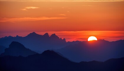 Obraz premium Sunset Over Mountains Silhouetted in Evening Glow