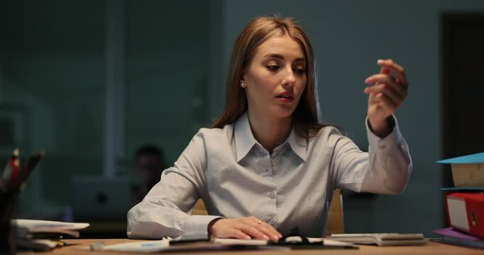 Tired woman checks imaginary wristwatch working late in corporate office. Female employee expresses exhaustion and stress of overloading