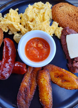 Desayuno tradicional Guatemalteco, servido con huevos revueltos, frijoles, queso fresco, pl&aacute;tanos fritos, chorizo y pan. Fotograf&iacute;a gastron&oacute;mica tomada con el tel&eacute;fono m&oacute;vil. Toma superior.