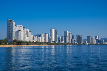 Fototapeta premium Panorama of the resort of Nha Trang city in Vietnam with a sandy beach by the sea and skyscrapers of hotels in summer