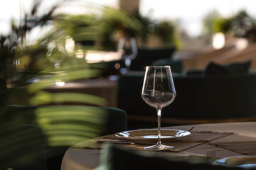 Stylish table setting. Glass glasses, plates, cutlery on the table. Wedding service, reception at the dining table. A birthday, a baptism, a festive event.
