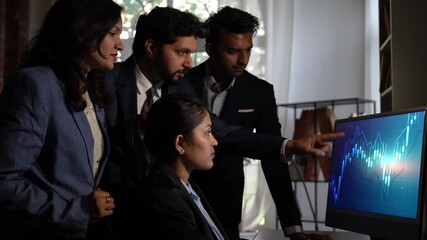 Young Indian professionals discuss, analyze stock market graphs on a laptop in the office - Powered by Adobe