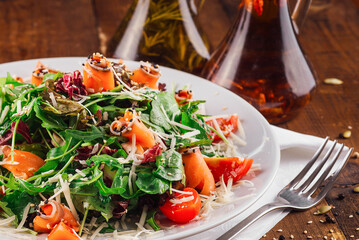 Delicious salad with arugula and salmon served on wooden table