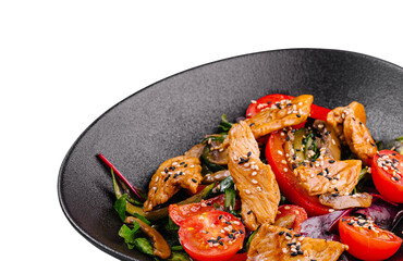 Delicious salad with grilled chicken and fresh vegetables on black plate