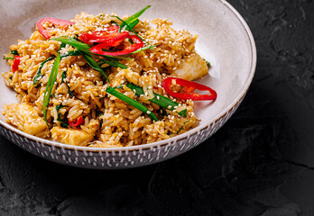 Spicy chicken fried rice garnished with green onion and sesame seeds