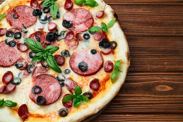 Pizza with mozzarella cheese , salami sausages , olives , and basil
