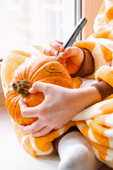 Child decorating a Halloween pumpkin