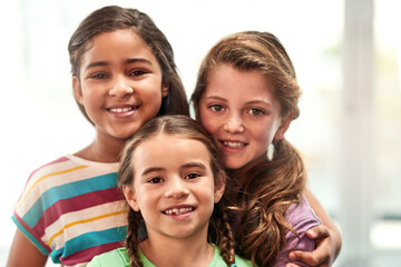 Portrait, children and friends with hug for care, connection and bonding together with support in kindergarten. Young girls, kids and love with embrace for solidarity, development or childhood growth