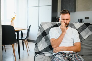 Dental health problems concept. Man suffering from strong toothache. Upset male patient with...