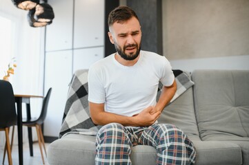 Man suffering from stomach ache at home. Food poisoning
