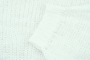 Close-up of a textured white knit fabric revealing its soft fibers and delicate structure