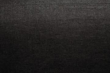 Solid black fabric with subtle texture displayed under soft lighting in a simple setting