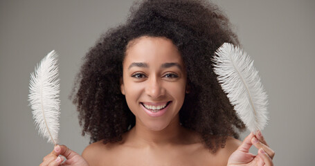 Health, beauty, tenderness and softness concept - beautiful African American woman with curly afro...