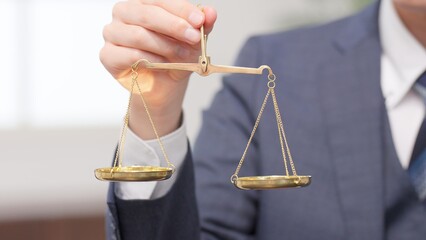 天秤を持つビジネスマンの手元
