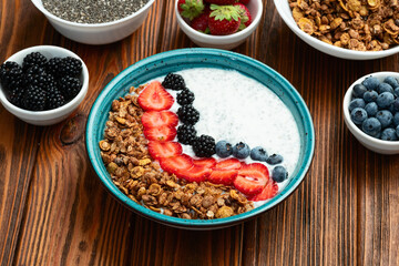 Healthy breakfast . Yogurt with berries ( strawberry , raspberry , blueberry , blackberry ) , granola and chia seeds . Top view