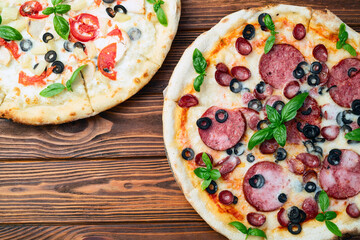 2 pizza with mozzarella cheese , salami sausages , olives , chicken , pineapple and tomatoes